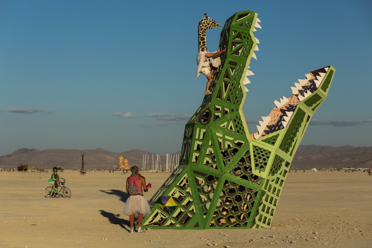 A Man In A Giraffe Costume Climbs On The Big Al Alligator by Brennan Steele | New Orleans, LA