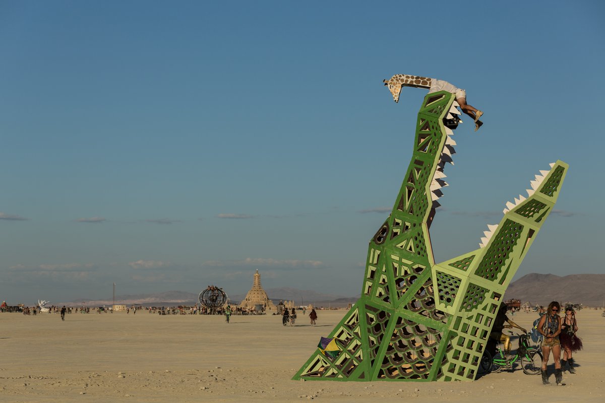 A Man In A Giraffe Costume Climbs On The Big Al Alligator by Brennan Steele | New Orleans, LA