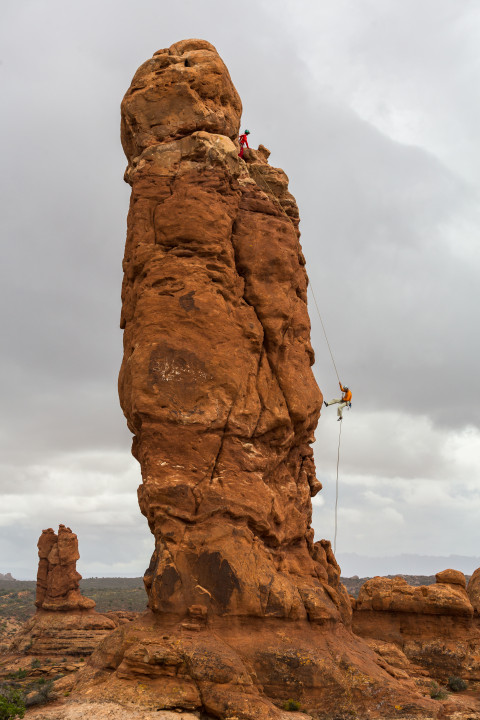 Climber Rappels Down Rock Formation