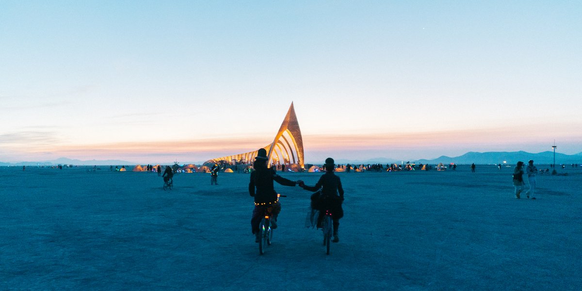 Couple Holding Hands As They Ride Their Bikes To The Temple Before Sunrise