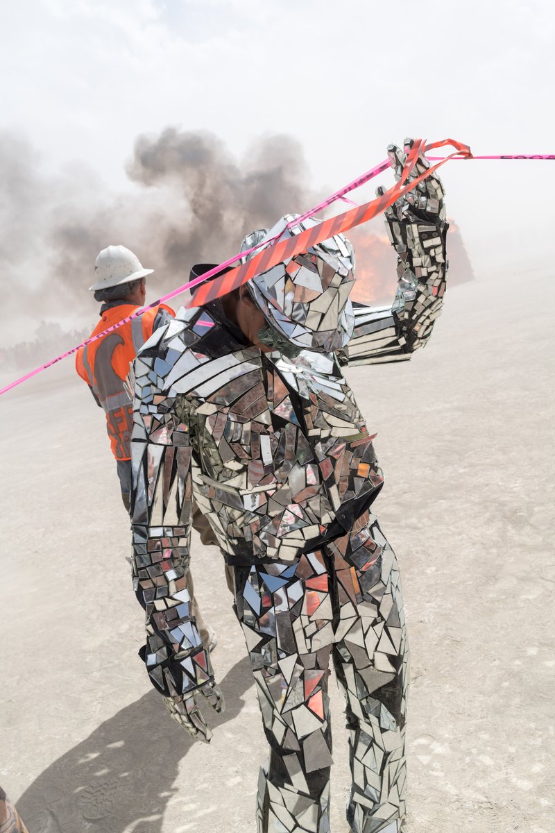 Man In A Costume Made Of Broken Mirrors Gets Caught Up In A Fence