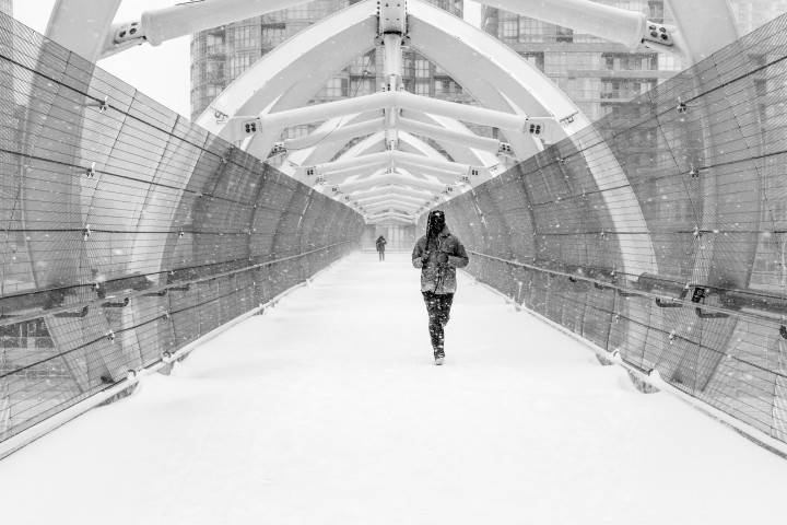 Man Running Across Pedestrian Bridge