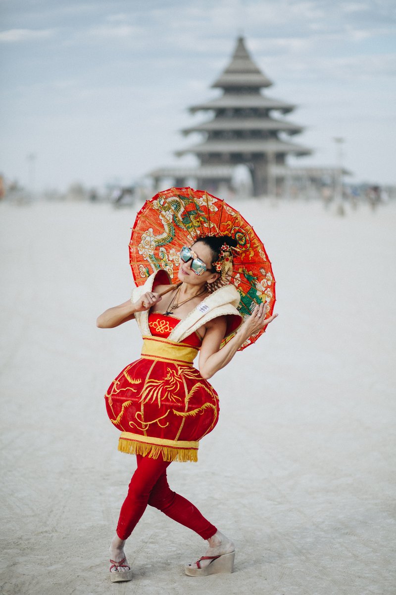 According to comment below: "Jade Phoenix in The Red Lantern, wearable sculpture designed by Anita Lam of Chinese Beyond Borders, celebrating Chinese culture on Playa."