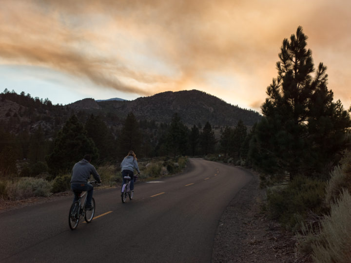 Couple Riding Bikes And Smoke From Wildfires