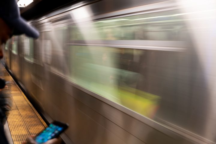 Man Looking At Phone While Waiting For The Subway