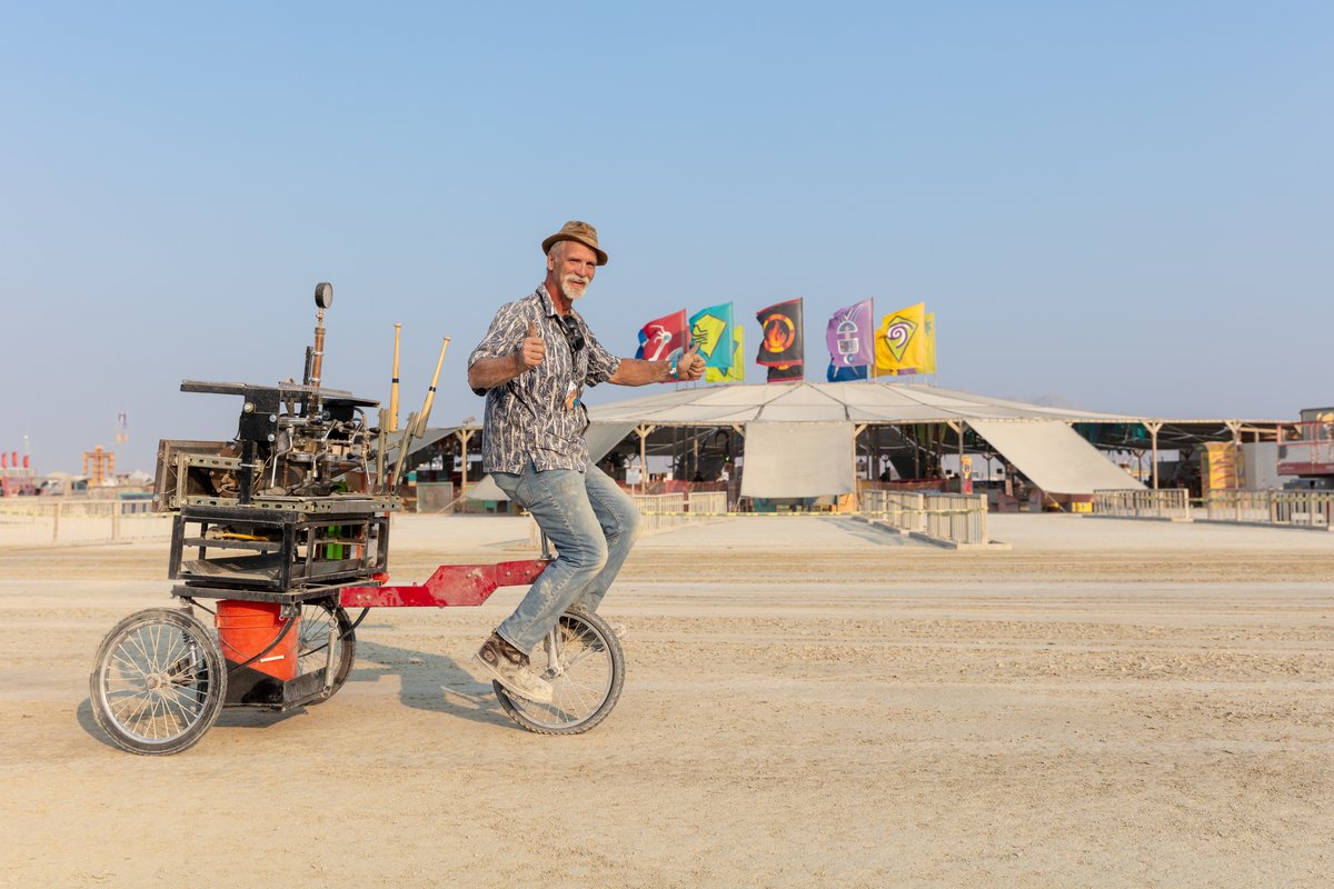 Shots Fired Espresso Cart by: PocoJoe and the Shots Fired Team from: Tucson, AZ year: 2018 (This fellow said can you take a photo of me so I can send it to my wife. She didn't think it was possible to put an espresso machine on a unicycle.)