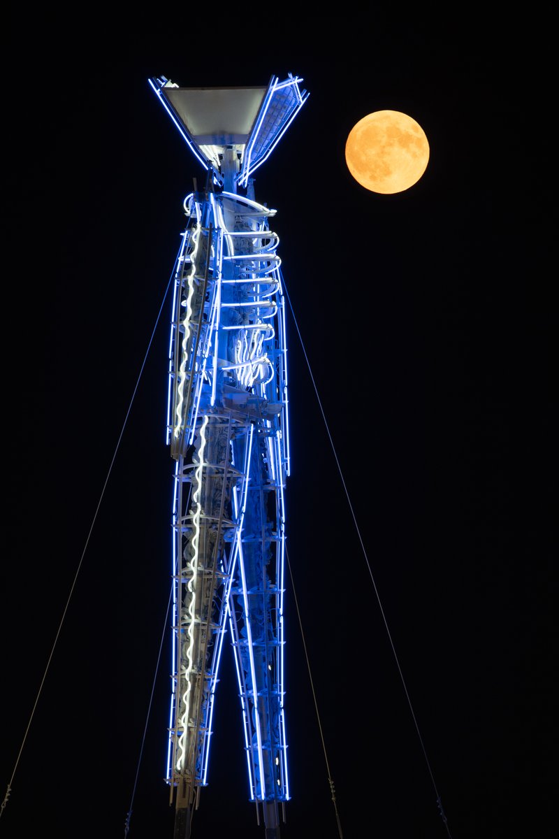 Quite a challenge to make a photo like this. You have to shoot the image of the moon and the man separetely because it's impossible to get them both perfectly in focus in-camera.