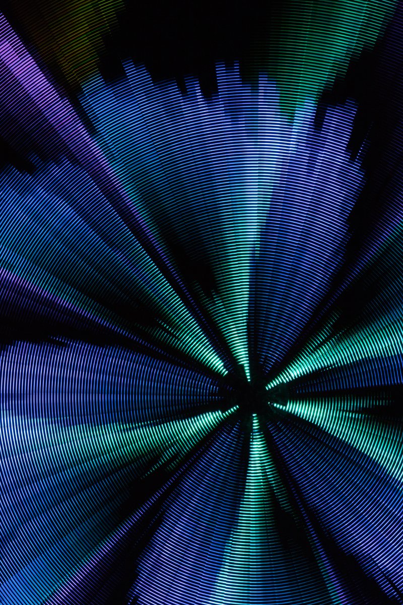 Paraluna by: Christopher Schardt from: Oakland, CA year: 2018 Paraluna combines kinetic sculpture, LEDs and music. Its main component is a disc 10m in diameter with 17,280 LEDs. A computer controls the LEDs while rotating, raising, lowering, and tilting the disc. Some of the LED patterns work with the rotation of the disk, creating spirals. Others use persistence-of-vision, making an image hover in space above the spinning LEDs. Spokes demonstrates both of these styles: https://photos.app.goo.gl/DcP9IauNTjRHENUh2 Surrounding the disc are several high-quality speakers that play classical music at comfortable, yet immersive volume, creating a comfortable, peaceful place to be. Patterns are chosen to complement each musical piece, as with Firmament: https://photos.app.goo.gl/H6KCzkf5jkGWAA3m2