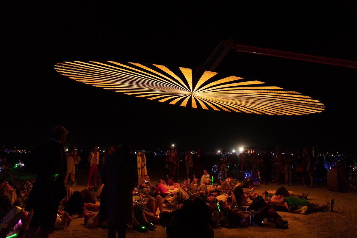 Paraluna by: Christopher Schardt from: Oakland, CA year: 2018 Paraluna combines kinetic sculpture, LEDs and music. Its main component is a disc 10m in diameter with 17,280 LEDs. A computer controls the LEDs while rotating, raising, lowering, and tilting the disc. Some of the LED patterns work with the rotation of the disk, creating spirals. Others use persistence-of-vision, making an image hover in space above the spinning LEDs. Spokes demonstrates both of these styles: https://photos.app.goo.gl/DcP9IauNTjRHENUh2 Surrounding the disc are several high-quality speakers that play classical music at comfortable, yet immersive volume, creating a comfortable, peaceful place to be. Patterns are chosen to complement each musical piece, as with Firmament: https://photos.app.goo.gl/H6KCzkf5jkGWAA3m2