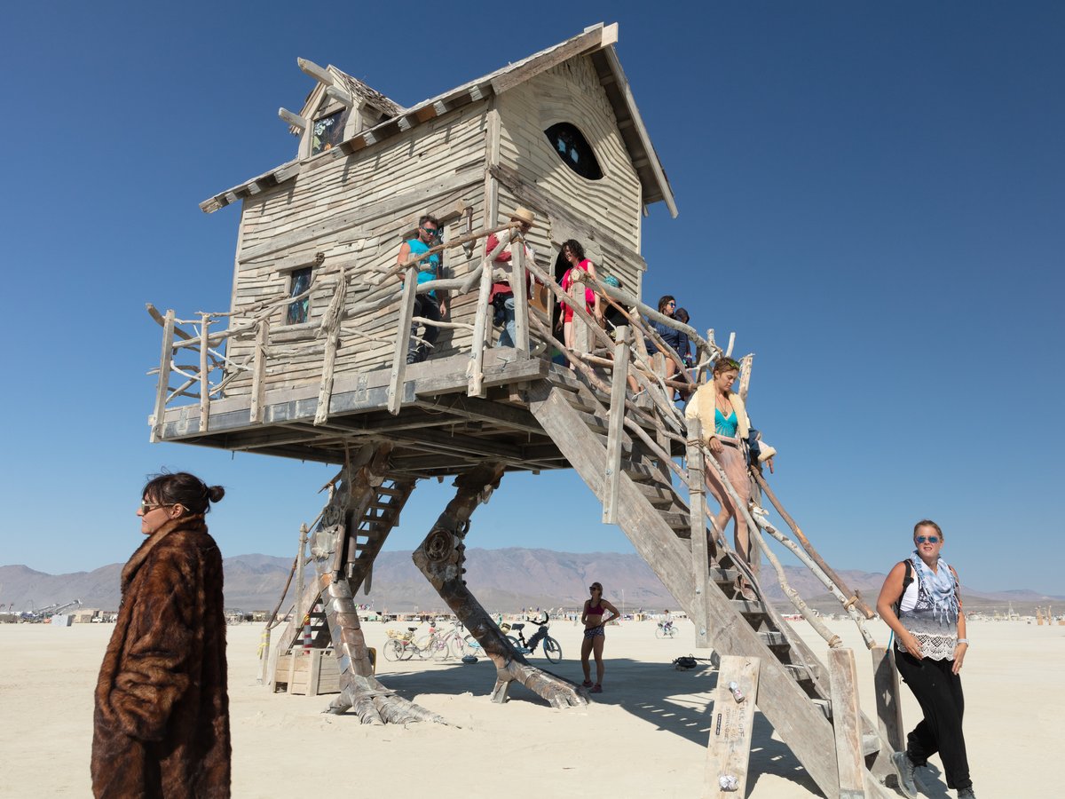 Baba Yaga's House by: Jessi Sprocket Janusee and Baba Yaga's Book Club from: Reno, NV year: 2018 The house of Baba Yaga will rise from the playa straddling it's mechanical chicken legs. The crone's house will be poised to run at the slightest provocation. Ascend her staircases to test the old witch if you dare. Are you able to walk through the veil of mortality into the space where the seer dwells? If you are strong of will, feeling bold and willing to show vulnerability she may allow you to venture within her sanctum. URL: http://jessisprocket.com/baba-yaga/