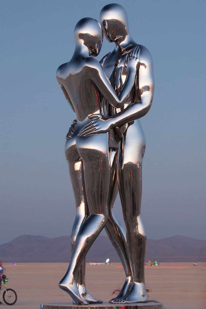 In Every Lifetime I Will Find You by: Michael Benisty, Love and Unity from: Brooklyn, NY year: 2018 A sculptural representation of Male and Female holding one another in a symbolic and universal position of caring in a display of Love and Unity. Measuring 25 feet tall and made out of mirror polished stainless steel.