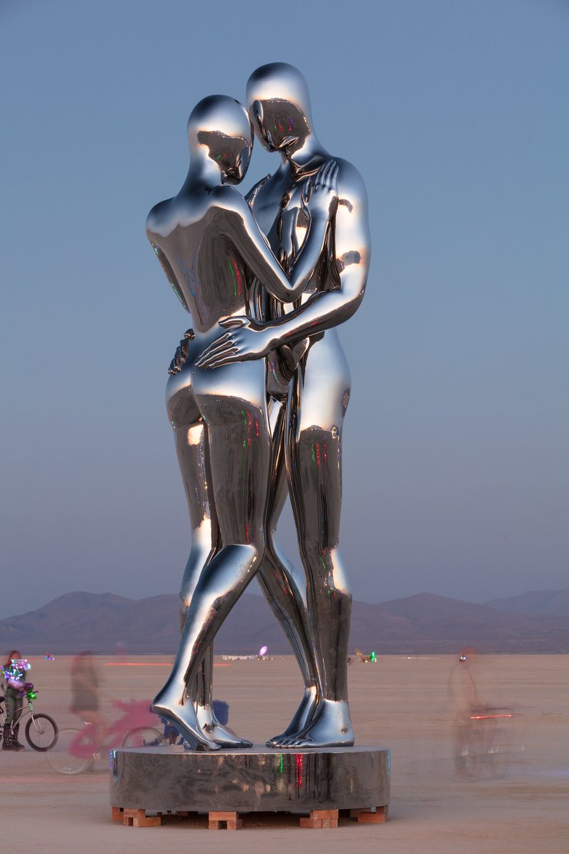 In Every Lifetime I Will Find You by: Michael Benisty, Love and Unity from: Brooklyn, NY year: 2018 A sculptural representation of Male and Female holding one another in a symbolic and universal position of caring in a display of Love and Unity. Measuring 25 feet tall and made out of mirror polished stainless steel.