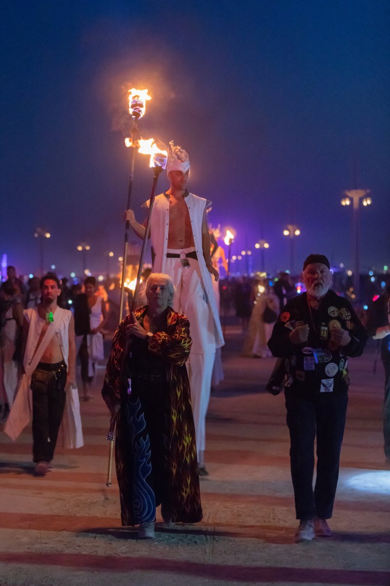Carrying the flame that will light the fires for the fire conclave dancers.