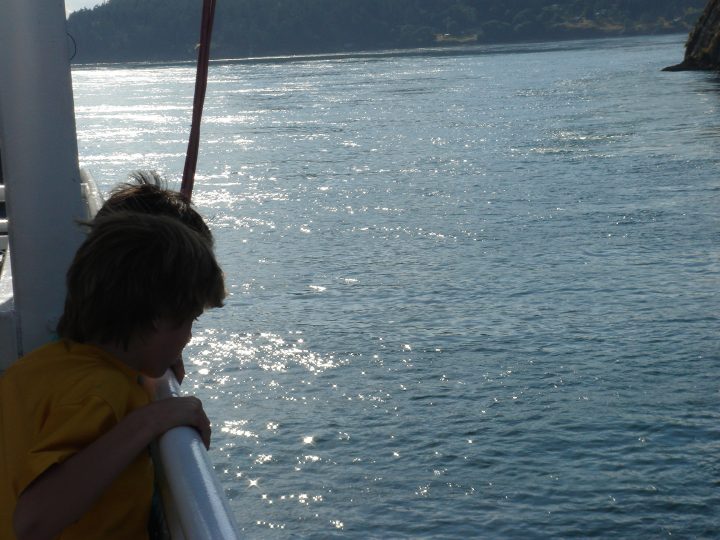 kids look over the edge of the ferry
