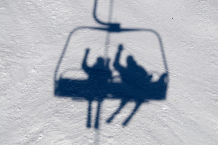 shadow of snow skiers on ski lift