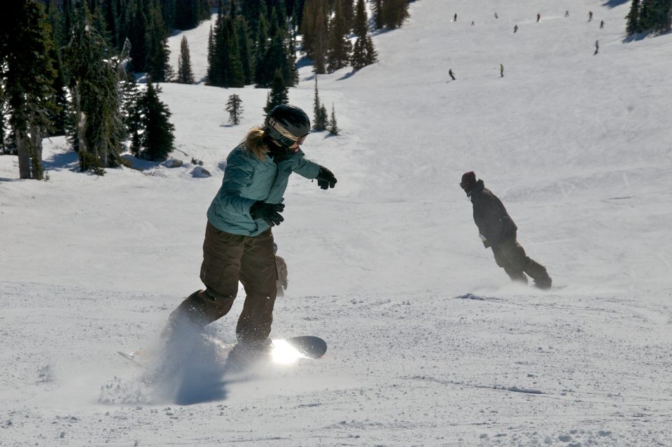 Snowboarders Riding Down The Hill