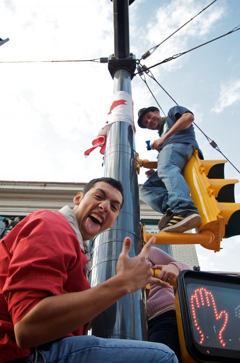 Fans Climb Street Lights