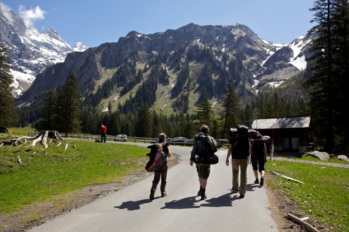Backpackers Hiking In The Swiss Alps
