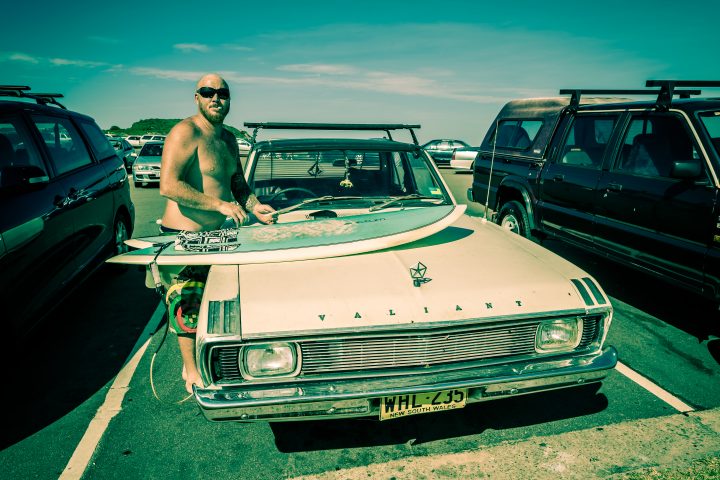 Surfer Waxing His Board On The Hood of a Car Merewether Australia