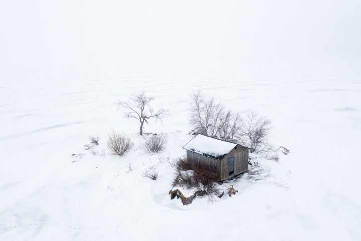 Small Island with Cabin Surrounded by Ice