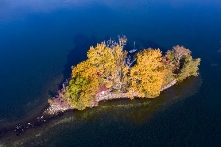 Small Island with Cottage and Sailboat