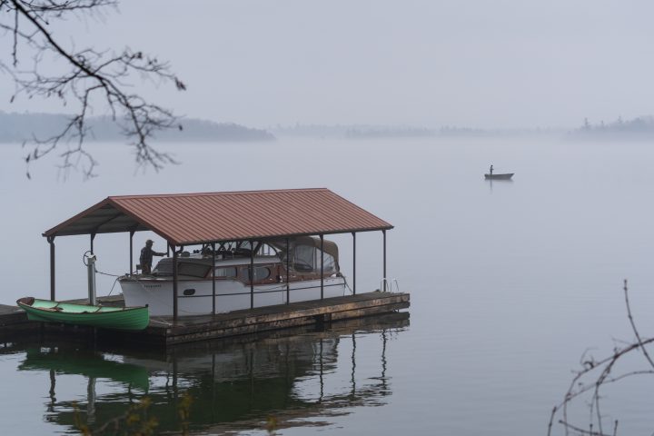 Young Man Fishing as Old Man Looks On