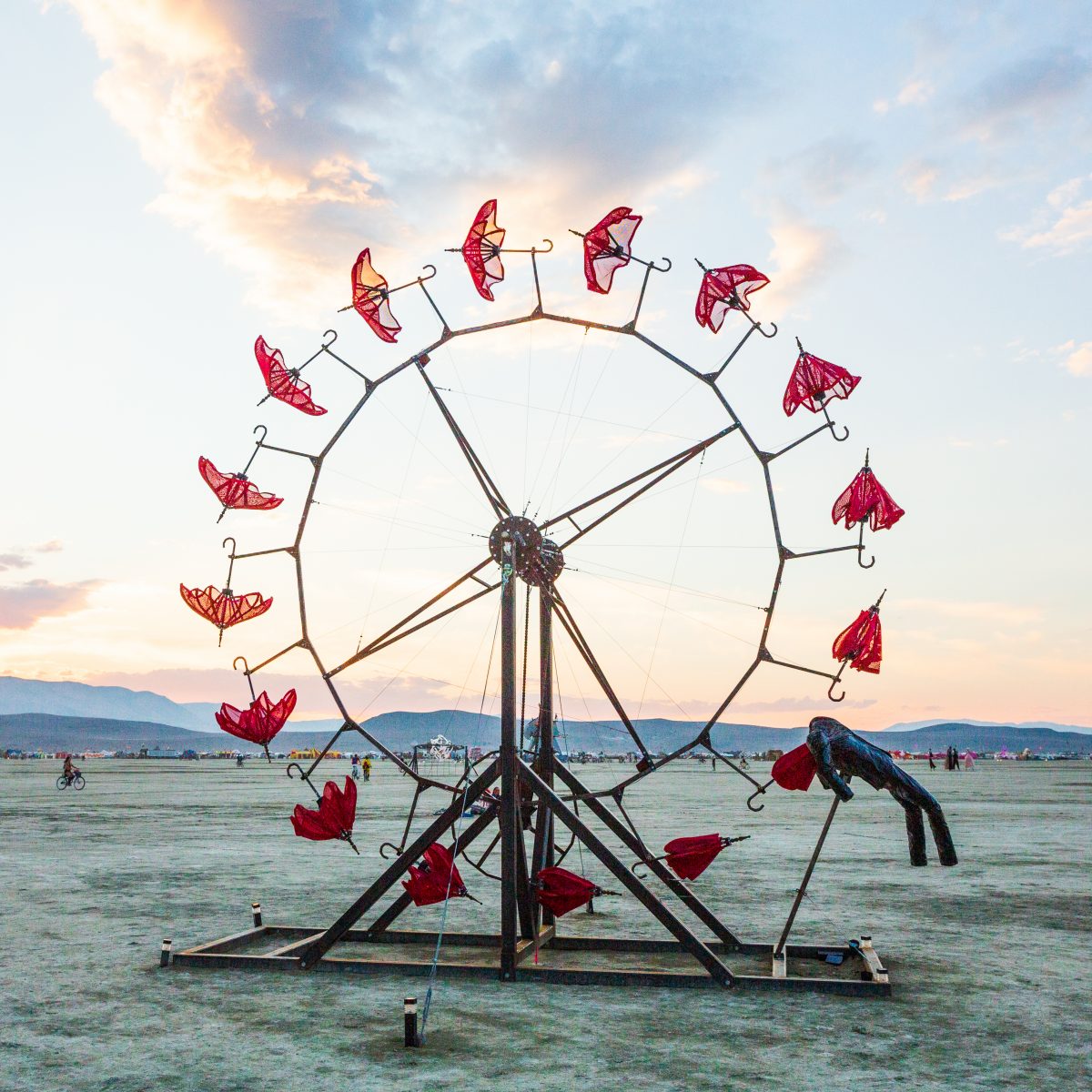 Parasolvent by: Dan Benedict from: Anaheim, CA year: 2014  Parasolvent is a mechanical expression of loss, release, healing and decay. Participants turn a crank to rotate a 20' tall ring of red parasols. The collapsed parasols rise up through the chest cavity of a human figure and gradually open ...