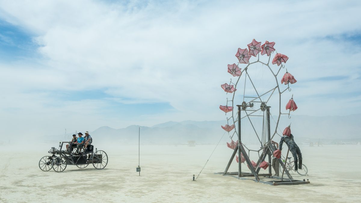 Mutant Vehicle and Parasolvent by: Dan Benedict from: Anaheim, CA year: 2014  Parasolvent is a mechanical expression of loss, release, healing and decay. Participants turn a crank to rotate a 20' tall ring of red parasols. The collapsed parasols rise up through the chest cavity of a human figure ...