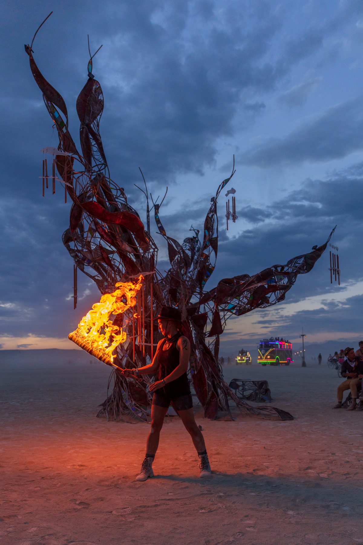 Firedancer at Methuselah is a 20′ metal sculpture of the world's oldest tree. The tree's bark is steel, patinated to blue, brown & white, and seams of glass reveal propane flames within the trunk, reflected in a mirror below. The tree's roots form benches on which Burners can congregate. Ance...