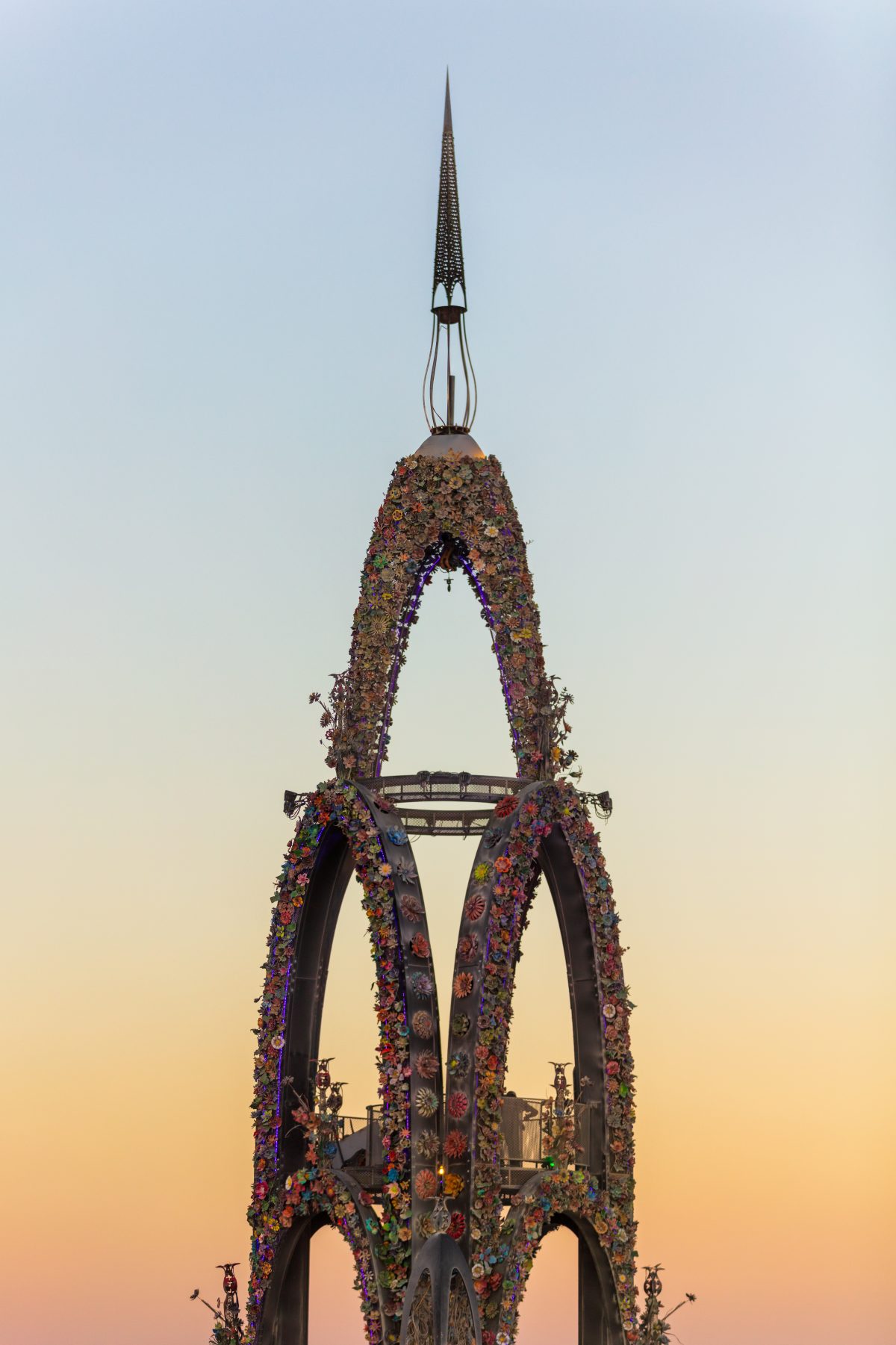 The Flower Tower by: Kevin Clark, Reared In Steel from: Petaluma, CA year: 2017  The Flower Tower is a 70 foot tall metal structure ornately decorated by thousands of painted metal flowers, some of which will blow fire. Contact: flowertower@rearedinsteel.com