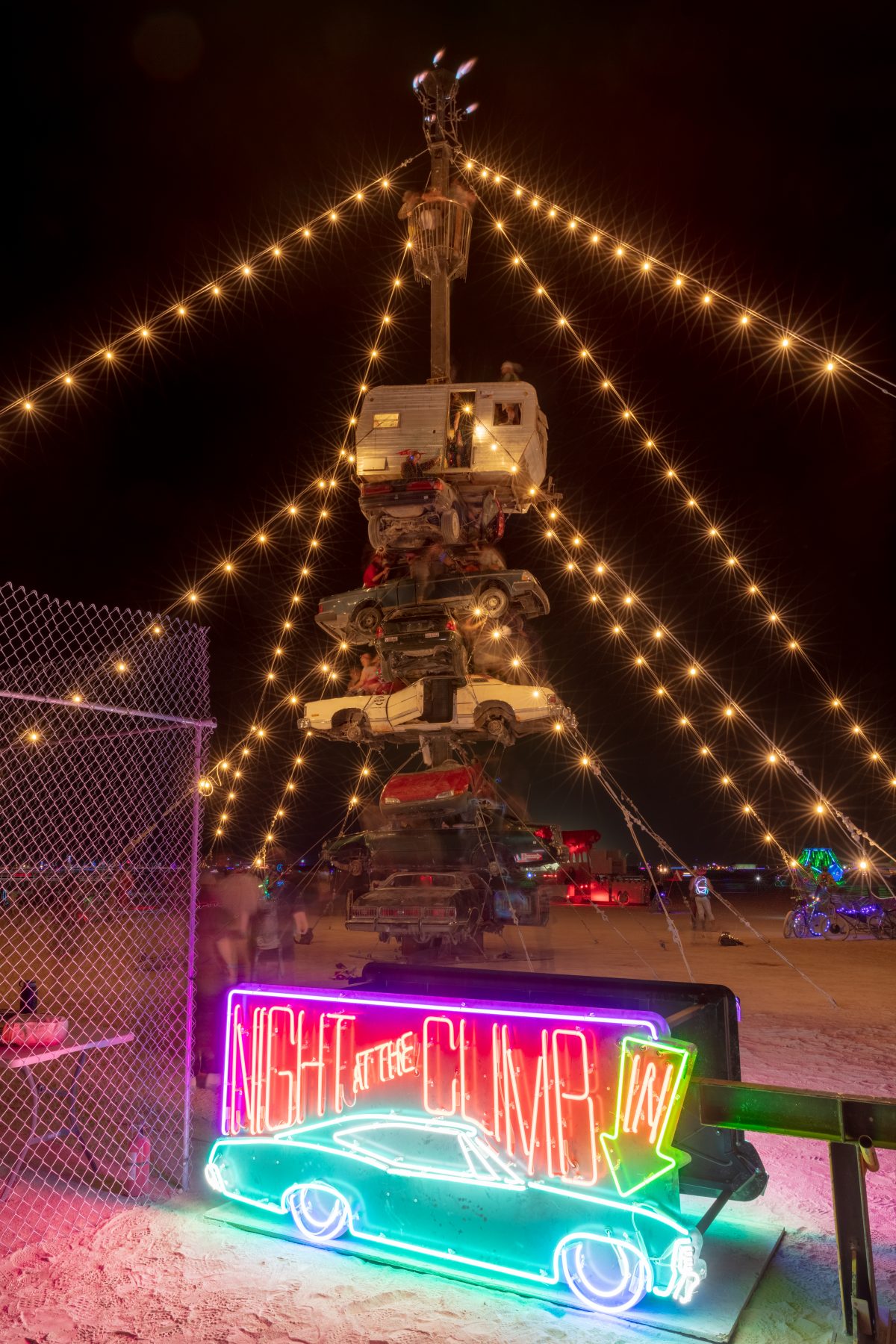 Night at the Climb In by: Dustin Weatherford from: Reno, NV year: 2018  Night at the Climb In will be a 70 foot tall stack of reclaimed junkyard cars, stacked straight up, one on top of the next. Every car will be climbable, visitable, interactive in its own way. The stack will end in a crows nes...