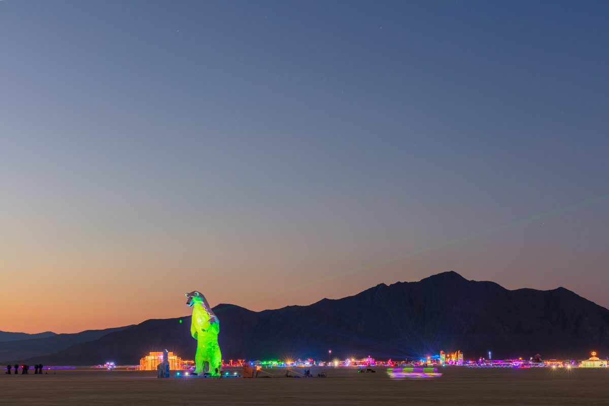 Long View, a polar bear stands in the desert by: Don Kennell and Arctic Burn 505 from: Santa Fe, NM year: 2018  A 34 foot polar bear made from white car hoods looks across the boundless vista of Black Rock City. The polar bear is an unlikely visitor to the Playa made from materials transformed fr...