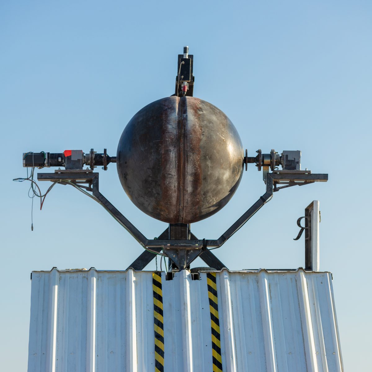 Ei Robot by: Spencer Edgerton, Launchpad Artspace at 3113 Studios, and Camp Deep Orbit from: Tucson, AZ year: 2018  A robot sits on a box and carves ideas into steel balls. The finished openwork balls surround the main robot sculpture and glow with an inner light, projecting the image of their ne...