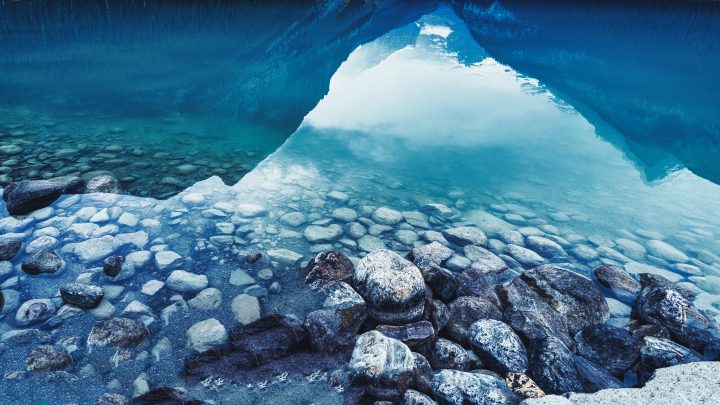 Reflection of Mountains and Stones on Shore