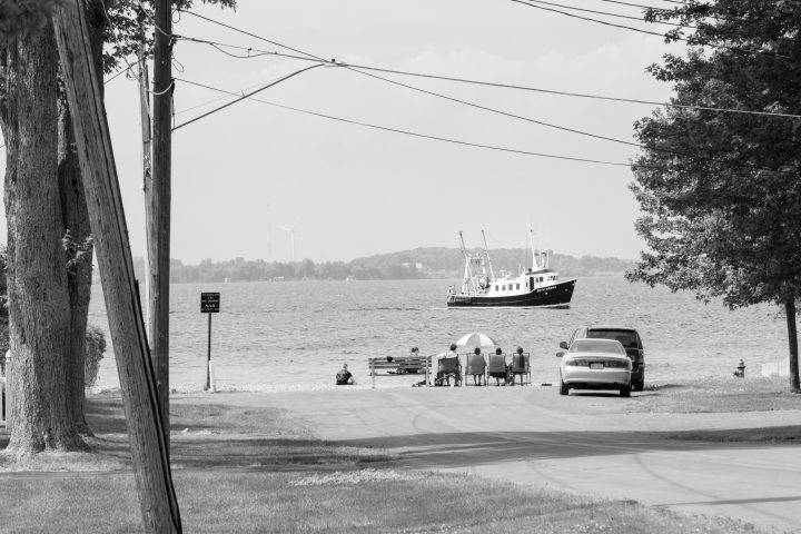 People on Shore Watching Boat