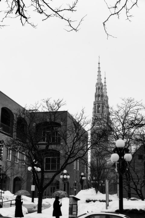 Two People with Umbrellas and Church