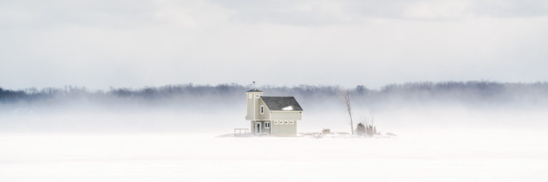 Small Island Surrounded by Ice and Blowing Snow