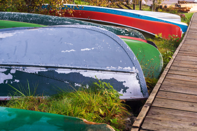 Weathered Boats and Canoes by a Wooden Dock