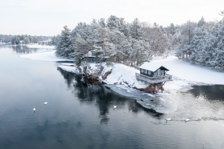 Cabin Over Water With Winter Swans