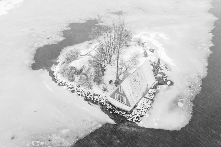 Snow-Covered A-Frame Cabin on Frozen Island